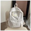 Detailansicht des cremeweißen Rucksacks mit gelbem Smiley-Patch und Kordelzugtasche - Weiß