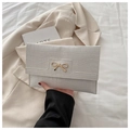 Close-up of white crocodile pattern PU leather clutch with golden bow metal buckle - White