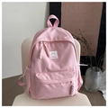 Detailansicht des rosa Nylon-Schulrucksacks mit modischem Aufnäher auf Stuhl - Rosa