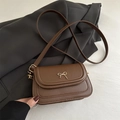Elegant brown leather crossbody bag with a chic golden bow detail for modern women - Brown