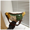 Detail of color-block saddle bag with drawstring and FASHION badge in macro view - Green