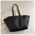 Detail of minimalist black tote bag with embossed fashion text and matte finish - Black