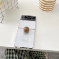 Detail of transparent Z Flip case with a glossy brown decorative ball ring grip - Brown / Samsung ZFlip3