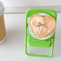 Détail du support de téléphone cœur avec nœud argenté sur mini chaise verte - Orange perlé