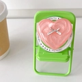 Vue macro d'un support de téléphone cœur perle rose avec nœud argenté décoratif - Rouge perlé