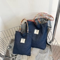 Dark blue denim tote bag with colorful braided handles and red checkered lining in a basket - Dark Blue Small