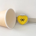 Detail der gelben Herz-Handyhalterung mit Schleifenmuster und Gift For You Sockel - Gelb