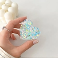 Dettaglio del supporto per telefono a cuore con paillettes colorate tenuto in mano - Paillettes Colorate Cuore N. 3