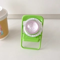 Detail of a purple glitter sphere on a mini green folding chair phone stand - Purple Glitter