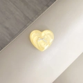Macro detail of heart-shaped phone grip with yellow pearlescent texture and silver bow - Yellow Glitter