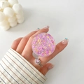 Detail of pink glitter phone socket grip held between fingers with matching heart ring - Pink Purple Fine Glitter Style (8)