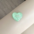 Detail of mint green heart phone socket with pearlescent texture and silver bow accent - Sparkling Green