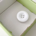 Close-up of white 4-hole round button phone grip with glossy resin finish for easy hold - White