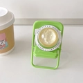 Close-up of green folding chair phone stand with sparkling gold glitter crystal ball - Yellow Glitter