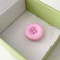 Detailed view of pink candy-colored button phone socket grip with four-hole design - Pink