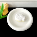 Detailed top view of a white Taiyaki-shaped phone grip with yellow layers on ceramic plate - Transparent Stand - Two-tone Fish / White