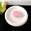 Pink Taiyaki shaped phone grip stand with textured scales on a minimalist tray - Transparent Stand - Two-tone Fish / Pink