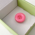 Macro detail of a pink button-style phone grip with a glossy resin finish and four holes - Rose Red