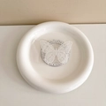 Detailed view of white lace butterfly phone grip on a gift card in a ceramic dish - Lace Butterfly-White