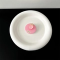 Detailansicht eines rosa glitzernden Erdbeer-Handyhalters auf einem weißen Teller - Transparenter Klebeständer / Rosenrot