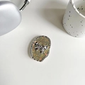 Detailopname van een glitter strik telefoonhouder op een wit bureau met accessoires - Pupil Flits Zilveren Strik / Donkergroen