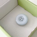 Macro view of light blue resin button phone grip with four-hole design in gift box - Light Blue
