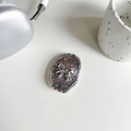 Detail van de ovale glitter telefoonhouder met een zilveren 3D-strik en sterrenglans - Pupil Flits Zilveren Strik / Zwart