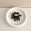 Macro detail of handmade metal tag on a black radial floral expanding phone stand - English Firework-Black