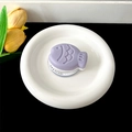 Macro detail of purple fish-shaped phone grip on white gift stand with floral decor - Magnetic Stand - Two-tone Fish / Purple
