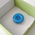 Detail of bright blue button cell phone socket with a transparent base on green box - Dark Blue