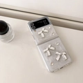 Detailed view of pearlescent Samsung Z Flip case with white 3D bows and sparkling rhinestones - Matte White Shimmer Drip Glue White Bow / Samsung ZFlip3