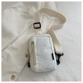 Detail of light blue chest bag with adjustable strap and fashion tag on corduroy jacket - White