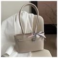 Detalle de bolso tote beige de piel sintética con hebilla plateada y lazo de cinta rosa - Caqui