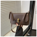 Détail d'un sac baguette marron foncé avec un fermoir rotatif doré en forme de capsule - Marron