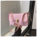 Detail of pink leather handbag featuring a curved flap and golden oval twist lock - Pink