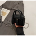 Dettaglio mini borsa nera con fibbia argentata e catena su una giacca grigia stile - Nero