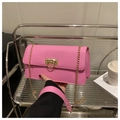 Detail of bright pink flap shoulder bag with gold chain strap on a stylish tray - Rose Pink