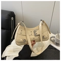 Detail of beige shoulder bag featuring silver metal buckles and eyelets in a Y2K style - Khaki