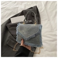 Detailed view of light blue denim mini handbag with fringe trim and golden chain strap - Blue