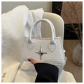Détail d'un sac à main blanc à texture tressée avec un ornement en métal en étoile - Blanc