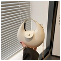 Detailed view of white crescent bag with gold sphere clasp and delicate metal chain - White