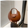 Detail of a brown leather crescent handbag featuring a gold clasp and metal chain strap - Brown
