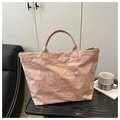 Macro detail of the light pink tote bag with crinkled texture and white TOTE BAG lettering - Pink