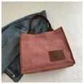 Close-up of pink corduroy tote bag with brown straps and leather fashion patch - Pink