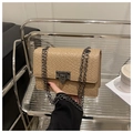 Detalle de bolso beige efecto cocodrilo con cadena metálica y cierre giratorio - Caqui