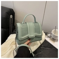 Detalle del bolso verde menta con textura de cocodrilo y correa de cadena metálica - Verde