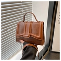 Macro view of caramel crocodile embossed faux leather handbag with silver chain - Brown