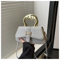 Nahaufnahme der Glitzerklappe und der goldenen H-Schnalle an einer grauen Luxushandtasche - Silber