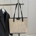 Elegante borsa tote crema con trama a pieghe e bordo nero, tendenza moda estate 2025 - Cachi