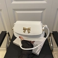 White retro leather crossbody bag featuring a golden 3D bow clasp and knotted strap detail - White